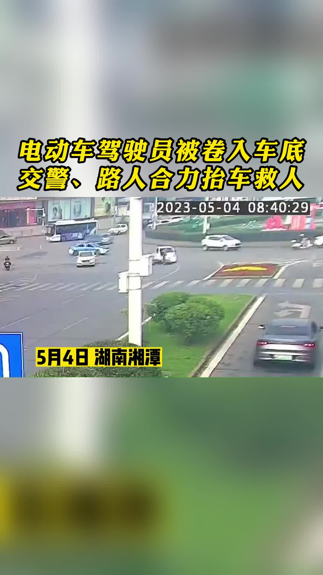 電動(dòng)車駕駛員被卷入車底 交警、路人合力抬車救人