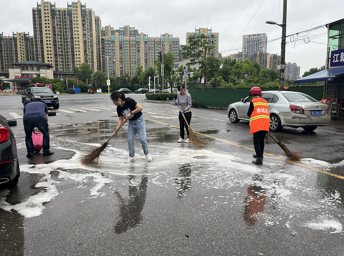 商城社區(qū)黨員志愿者及時清理路面油污消除隱患